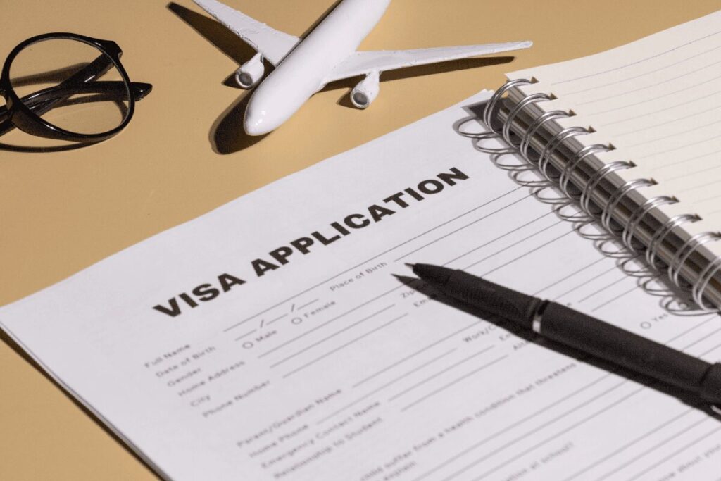 Visa application form with pen and travel accessories on desk