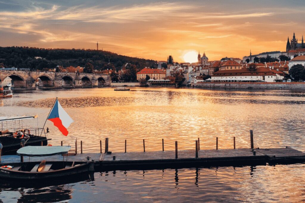 Boats on the Vltava River at sunset with Charles Bridge in Prague