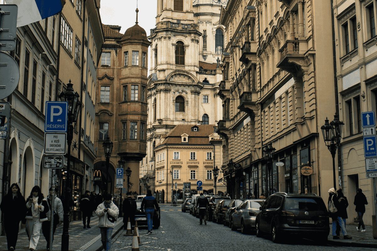 Cobbled street in Prague’s Old Town with parked cars and historic buildings