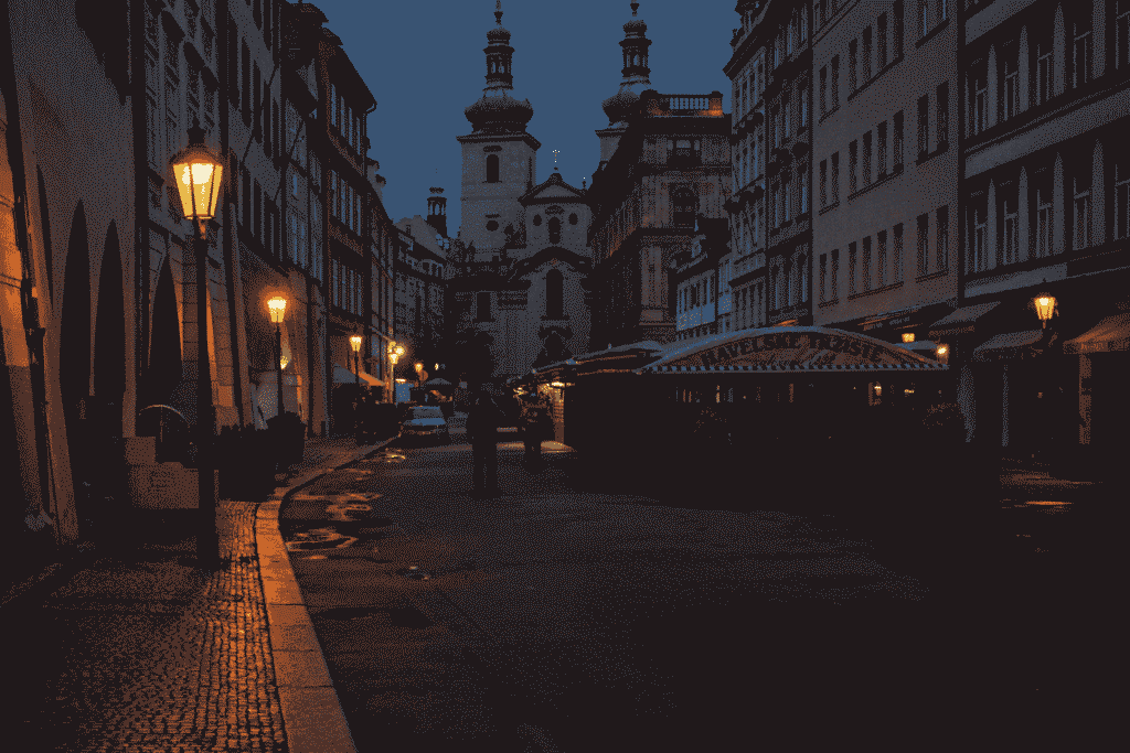 Historic street in Prague at night with illuminated buildings and cobblestones