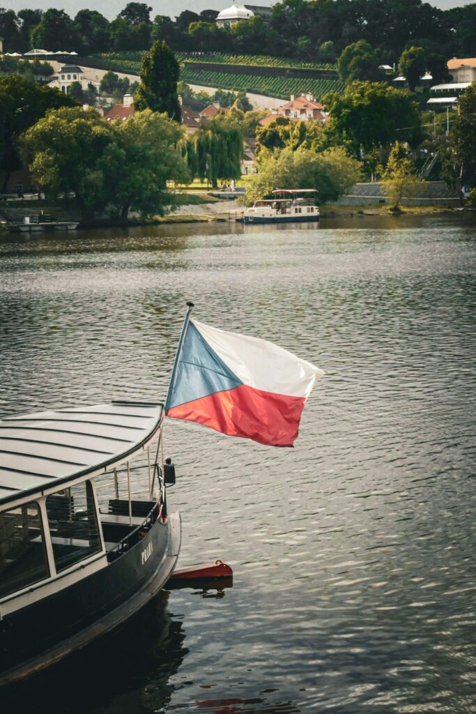 Czech Republic flag waving on Vltava River boat in Prague