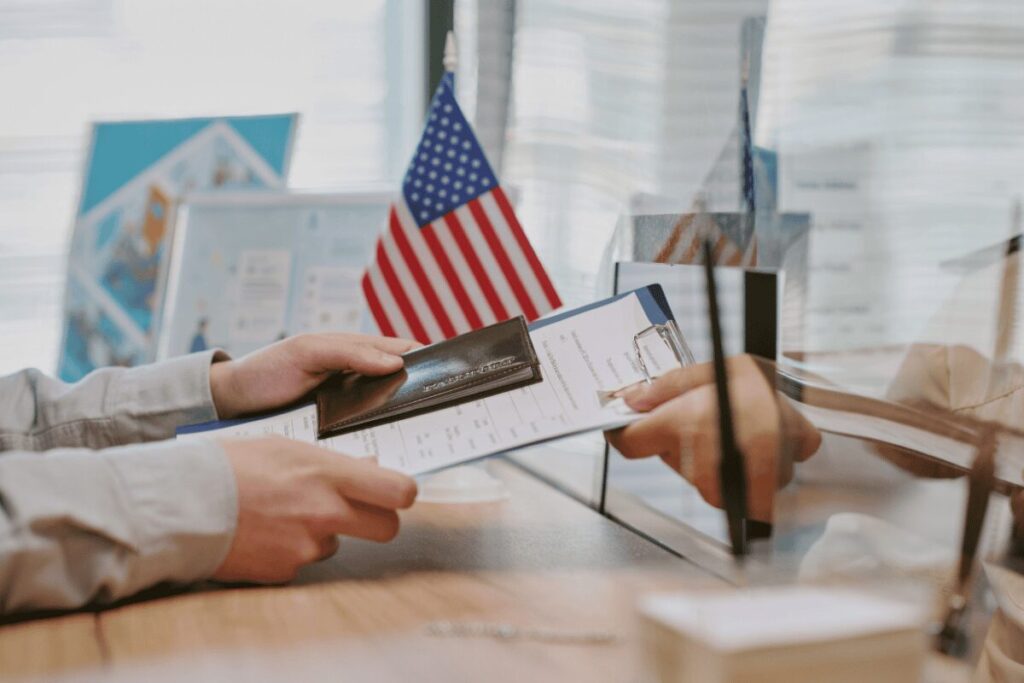 Submitting passport and paperwork at a consulate window during a visa application appointment