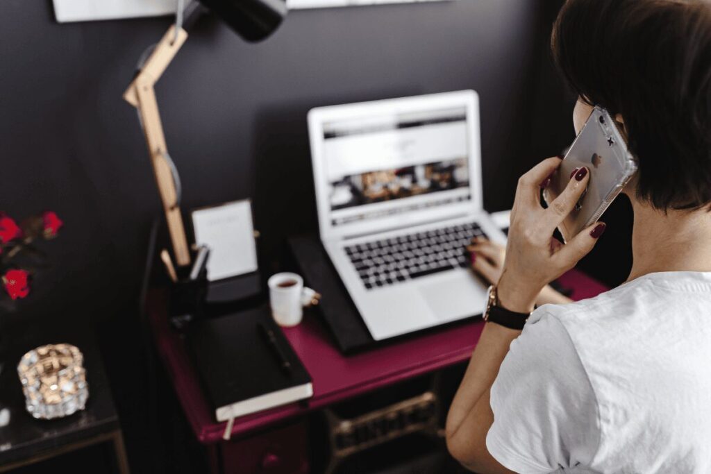 Woman making a phone call while on the laptop