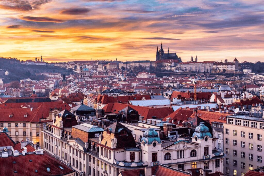 Prague skyline at sunset with red rooftops and Prague Castle above the city
