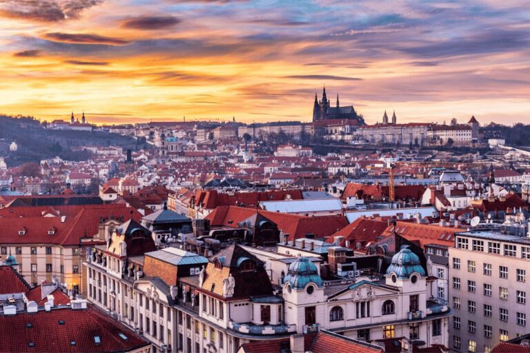 Prague skyline at sunset with red rooftops and Prague Castle above the city