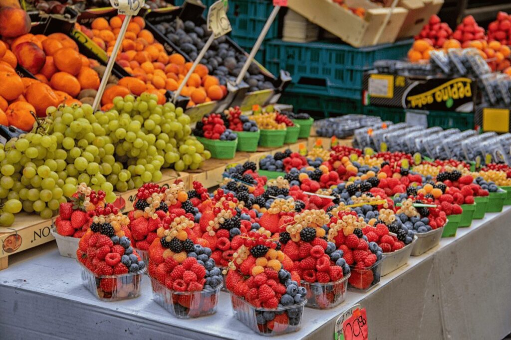 Fresh berries and fruit at a farmers market stall in Prague.
