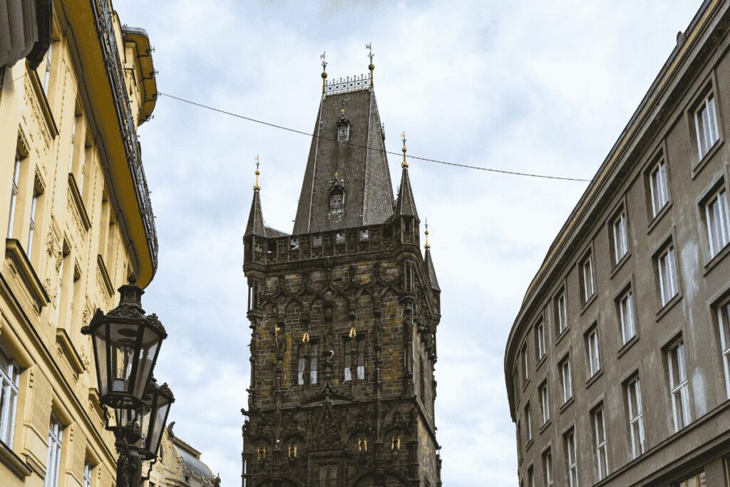 Historic Powder Tower rising above a street in Prague Old Town.