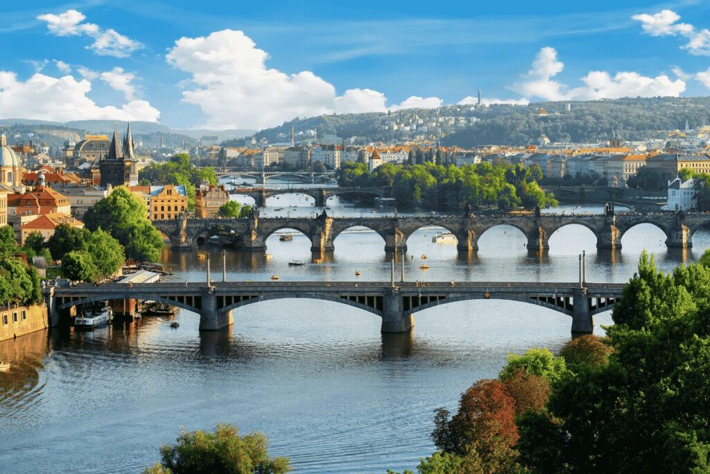 Scenic overlook from Letná Park showing the Vltava River, historic bridges, and the Prague skyline.