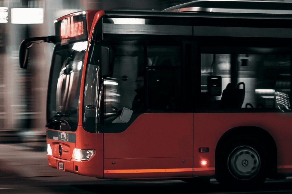 Red Prague night bus in motion on a city street after dark